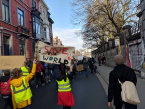 Climate marchers in Ghent with a banner that reads "save the world"